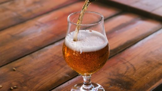 a beer being poured into a glass on a table