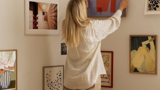 woman decorating her home with artwork