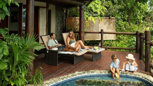family sitting next to pool